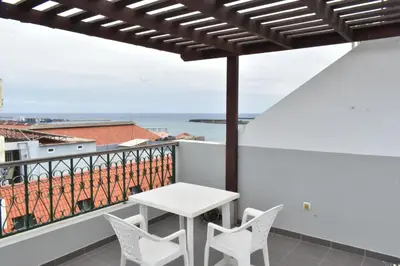 a white table and chairs on a balcony with a view at Casa Berta - Downtown Apartment in Praia