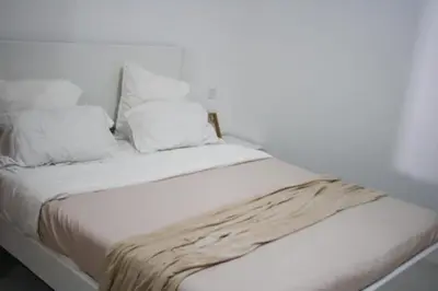 a white bed with white sheets and pillows at Rooms in Apartment Morabeza in Praia Cidadela in Praia
