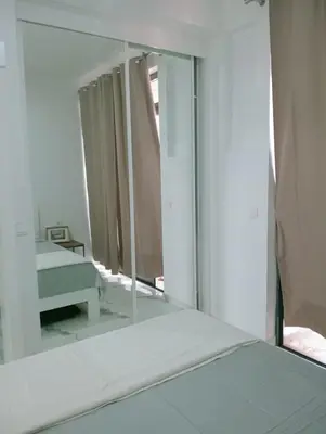 a mirror in a room with a bed and a bedroom at Apartamento Cidade in Mindelo