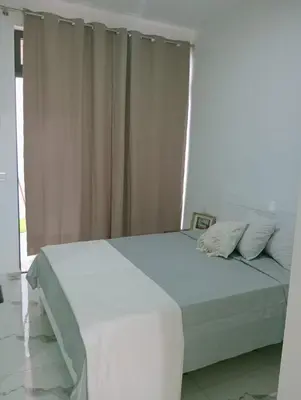 a white bed in a room with a window at Apartamento Cidade in Mindelo
