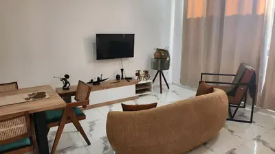 a living room with a tv and a table and chairs at Apartamento Cidade in Mindelo