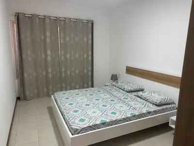 a bedroom with a bed with a gray curtain at Paz, Tranquilidade e Conforto in Espargos