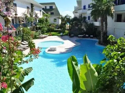a large blue swimming pool next to a building at Stunning, spacious penthouse in beach front Leme Bedje Residence in Santa Maria