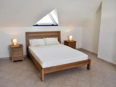 a bedroom with a bed and two night stands with lamps at Stunning, spacious penthouse in beach front Leme Bedje Residence in Santa Maria