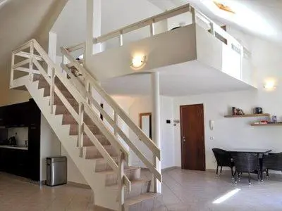 a staircase in a room with a table and chairs at Stunning, spacious penthouse in beach front Leme Bedje Residence in Santa Maria