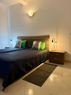a bedroom with a bed with green pillows and a night stand at Estrela Mar - Wi-Fi included in Santa Maria