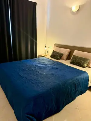 a bed with a blue comforter in a bedroom at Estrela Mar - Wi-Fi included in Santa Maria