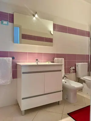 a bathroom with a sink and a toilet and a mirror at Estrela Mar - Wi-Fi included in Santa Maria