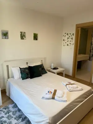 a bedroom with a bed with two towels on it at Vila Verde TownHouse T53 by RPG Group in Santa Maria