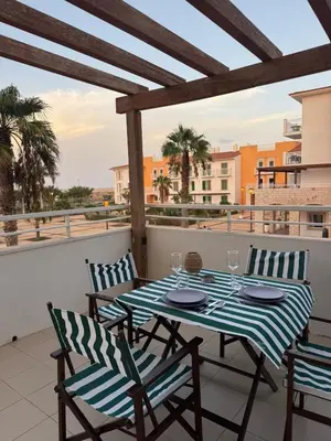 a table and chairs on a balcony with a view at Vila Verde Lantana B103 by RPG Group in Santa Maria