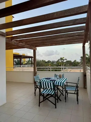 a patio with a table and chairs on a roof at Vila Verde Lantana B103 by RPG Group in Santa Maria
