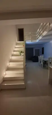 a staircase in a room with a table and chairs at Apartamento Duplex Boa Vista in Sal Rei