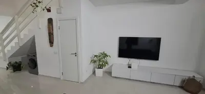 a white living room with a flat screen tv on a wall at Apartamento Duplex Boa Vista in Sal Rei