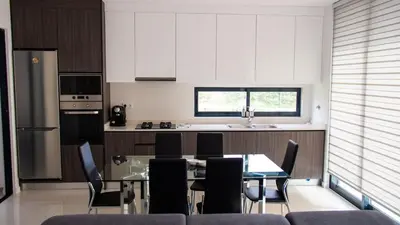 a kitchen with a glass table and chairs in it at Domus Lima in Mindelo