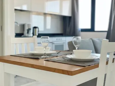 a wooden table with two wine glasses and a bowl at Apartamento T1 - MedSal Residence in Santa Maria