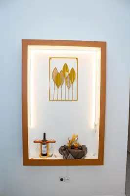 a mirror on a wall with a picture of leaves at T1 Mindelo City Center in Mindelo