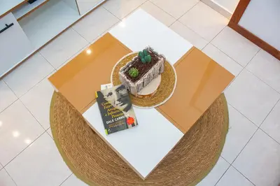 a table with a slice of cake and a book at T1 Mindelo City Center in Mindelo