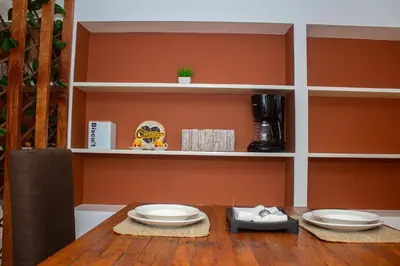 a dining room with a table with plates on it at Studio City Center in Mindelo