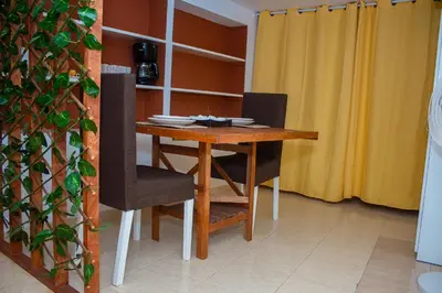 a dining room table with two chairs and a table and chairsuggest at Studio City Center in Mindelo