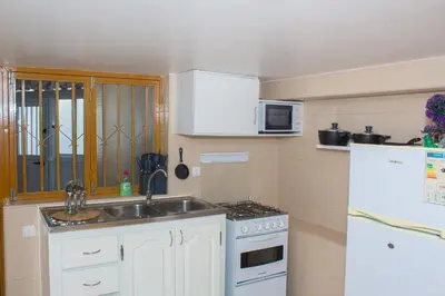 a small kitchen with a sink and a refrigerator at Studio City Center in Mindelo