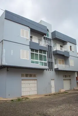 a large white building with two garages at Studio City Center in Mindelo
