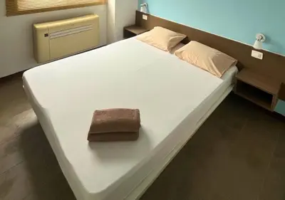 a large white bed with a brown towel on it at MonteCara View T1 in Mindelo