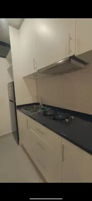 a kitchen with white cabinets and a sink and a stove at Castro AP in Mindelo