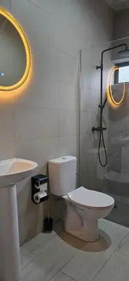 a bathroom with a toilet and a sink and a shower at The Pink Banana in Paul