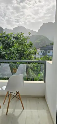 a white chair sitting on a balcony with a view at The Pink Banana in Paul