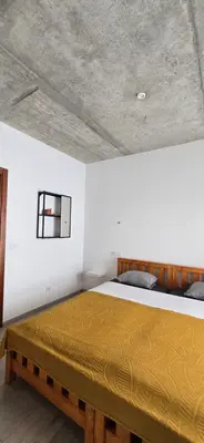 a bedroom with a large bed with a yellow blanket at The Pink Banana in Paul