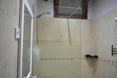 a bathroom with a shower with a glass door at Cozy Palm in Praia