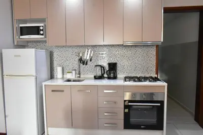 a kitchen with white appliances and a white refrigerator at Cozy Palm in Praia