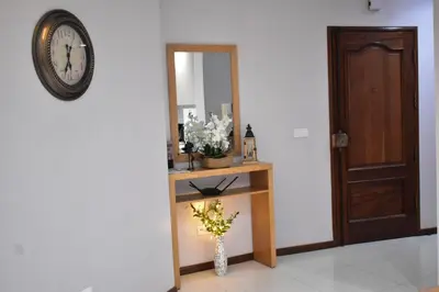 a room with a clock and a table with flowers at Cozy Palm in Praia