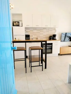 a kitchen with a counter and stools in it at Lamore 01 - more comfortable of all in Beirona