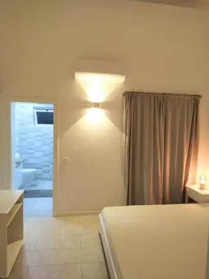 a bedroom with a bed and a light on the wall at Lamore 01 - more comfortable of all in Beirona