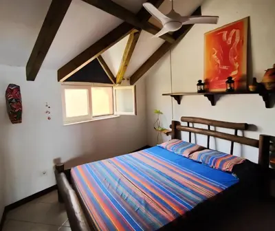 a bedroom with a bed and a ceiling fan at Ibiscus Penthouse in Santa Maria