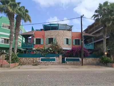 a house on the side of a street with palm trees at Ibiscus Penthouse in Santa Maria