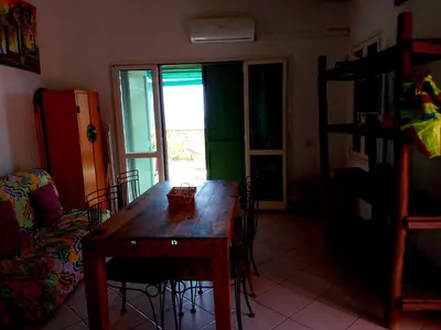 a room with a wooden table and chairs and a window at Ibiscus Penthouse in Santa Maria