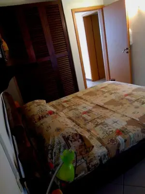 a bedroom with a bed with a quilt on it at Ibiscus Penthouse in Santa Maria