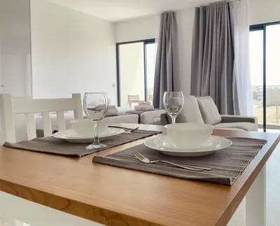 a dining room table with two plates and wine glasses at Apartamento T0 - MedSal Residence in Prainha