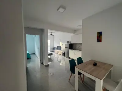 a kitchen and dining room with a table and chairs at APARTAMENTOS COSTA MCC - New apartments near city center & beach in Santa Maria