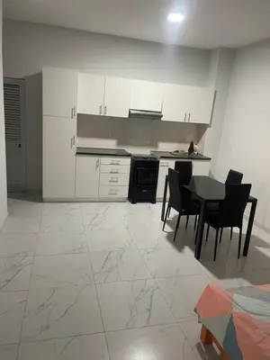 a kitchen with white cabinets and a table and chairs at T0 Brisa Tropical in Sal Rei