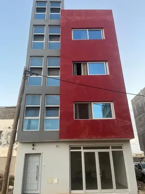 a red and white building with glass windows at T0 Brisa Tropical in Sal Rei