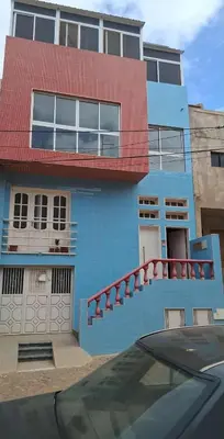 a blue building with a red balcony on it at CasaTanha in Mindelo