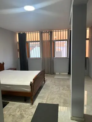 a bedroom with a bed in a room with windows at CasaTanha in Mindelo