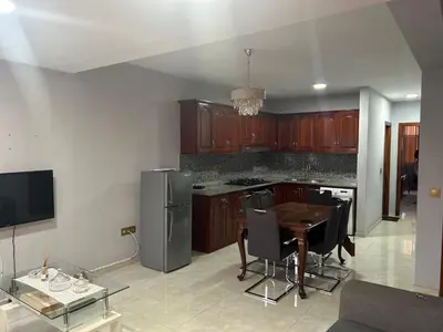 a kitchen with wooden cabinets and a table with chairs at CasaTanha in Mindelo