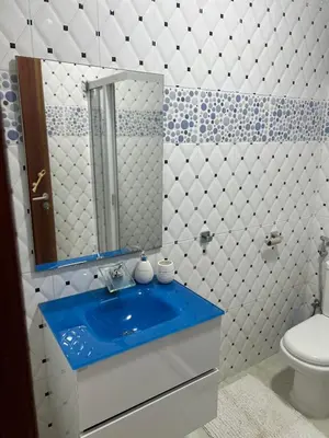 a bathroom with a blue sink and a toilet at CasaTanha in Mindelo