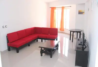 a living room with a red couch and a table at T3 Mindelo in Mindelo