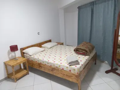 a bedroom with a wooden bed and a table at T3 Mindelo in Mindelo