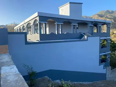 a house painted blue with a fence at Djabraba's kaminhu Double in Vila Nova Sintra